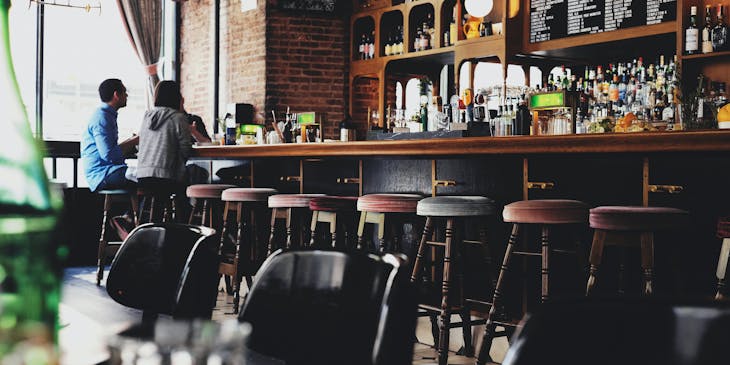 Personas sentadas en un bar.