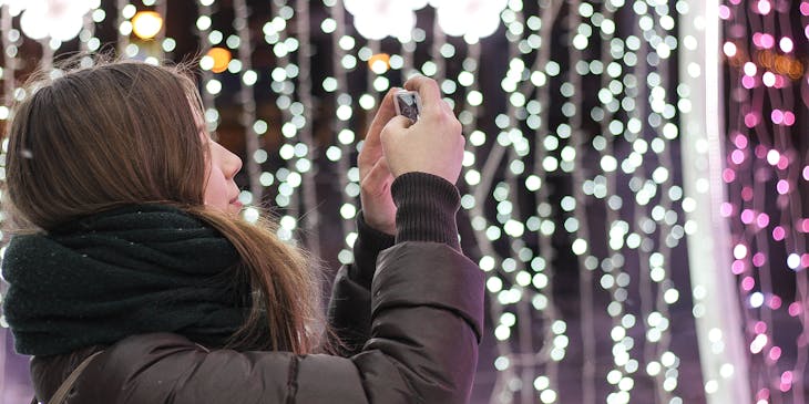 Une femme qui installe une illumination de Noël.