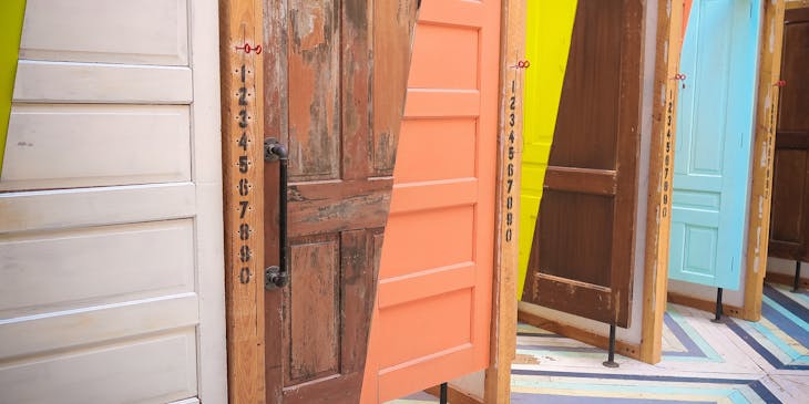 Interesting and colorful row of partially or fully painted wooden doors.