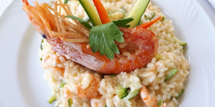 Risotto ai frutti di mare con verdure su un piatto bianco.