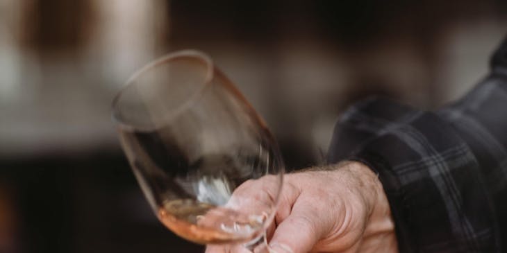 Un sommelier che fa areare del vino rosé prima della degustazione durante un corso per sommelier.