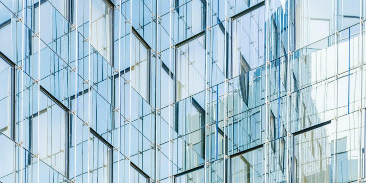 The exterior of a building coated in glass.