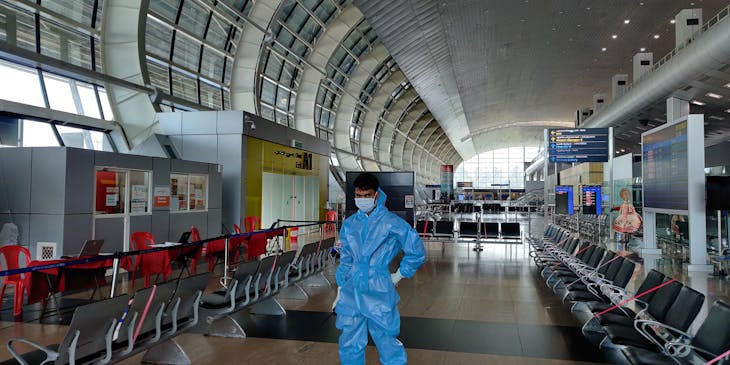 A man wearing personal protective equipment (PPE) in an airport.