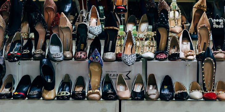 Ladies shoes and boots displayed on shelves in a shoe store.