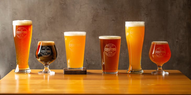 Seis vasos cerveceros servidos con distintas cervezas de una empresa de cerveza artesanal.