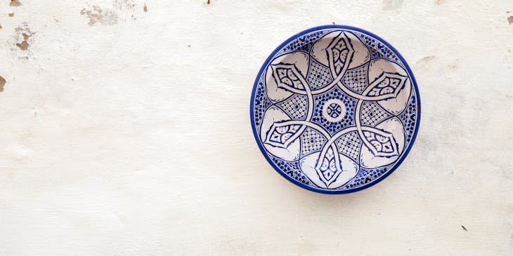 Dos platos de talavera colgados de una pared blanca descarapelada en un negocio de productos artesanales.