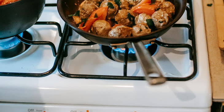 Una sartén con albóndigas suecas sobre una estufa en un restaurante de cocina nórdica.