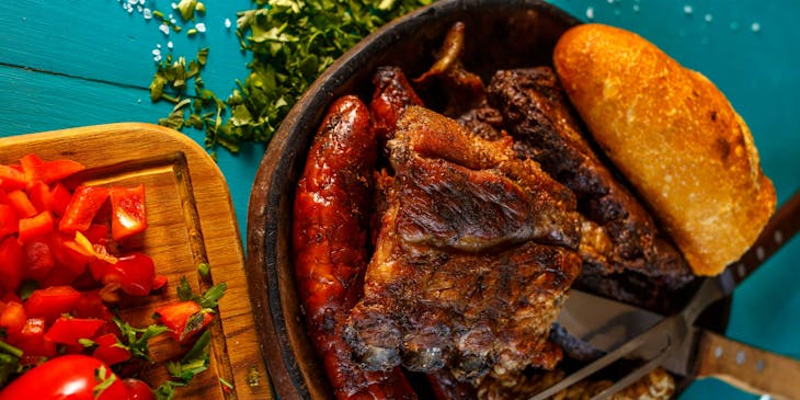 Un asado servido junto a unos pimientos rebanados en un restaurante uruguayo.