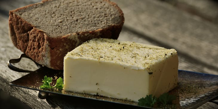 Un morceau de beurre et de pain dans un plat en métal sur une table.