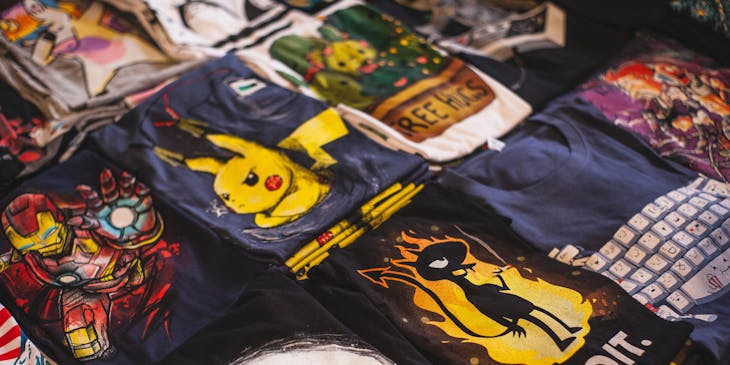 Une table avec plusieurs t-shirts aux dessins floqués.