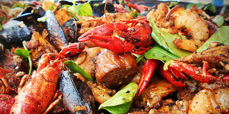 Un plat de fruits de mer épicé avec langoustes, crevettes et moules.