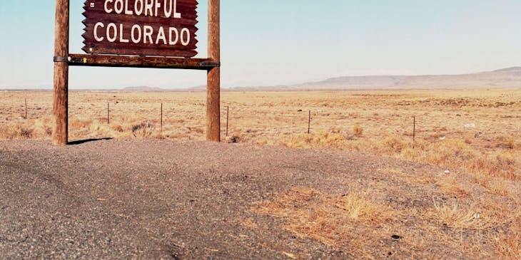 Un letrero en el desierto que dice "Bienvenidos al colorido Colorado" en inglés en una empresa en Colorado.