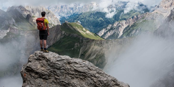 Um alpinista ambicioso analisando uma montanha.