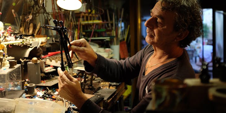 Un restauratore che lavora nel suo studio effettuando un servizio di restaurazione di antichità.