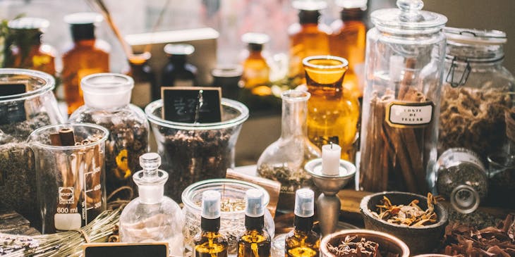 The back shelf of an apothecary lined with bottles of oils and other business.