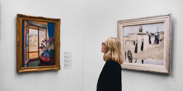 Une femme admire un tableau dans une galerie d'art.