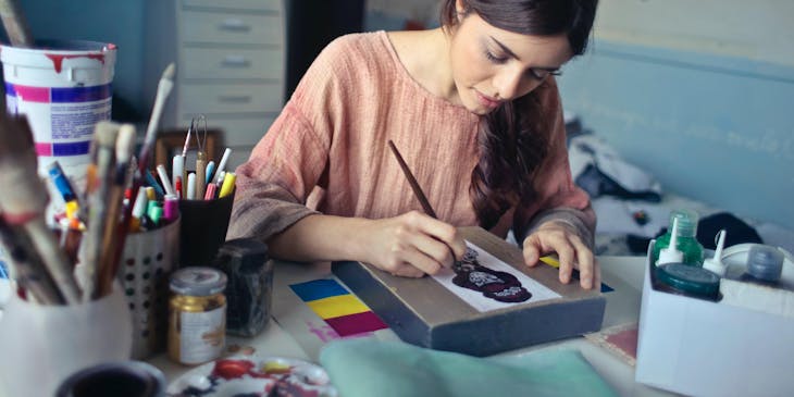 A woman painting at art therapy class.