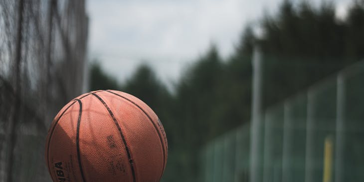 Una palla da basket su una superficie di cemento all'interno di un campo da basket.