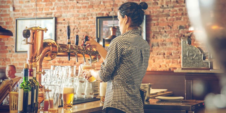 Bartender servindo cerveja em uma choperia.