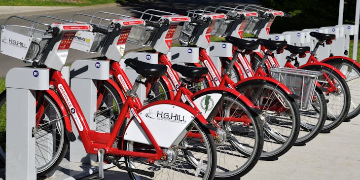 Une rangée de vélos rouges devant un commerce de vélos.