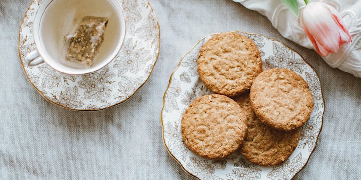 Biscoitos em um prato ao lado de uma xícara de chá.