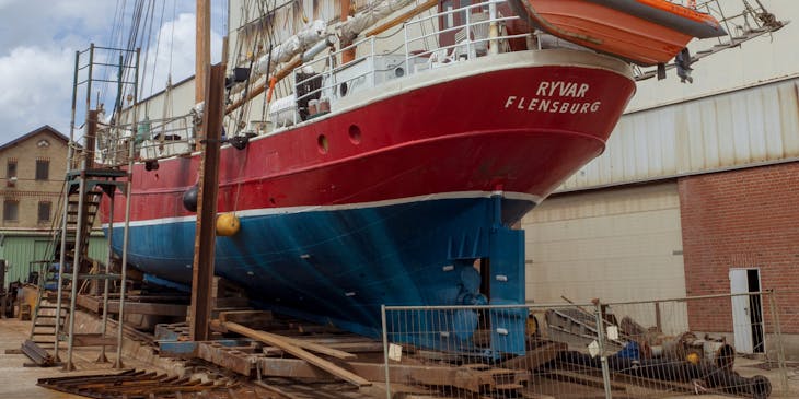 Un barco en tierra siendo reparado en un negocio de reparación de barcos.