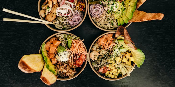 Quatro poke bowls em um restaurante de bowls.