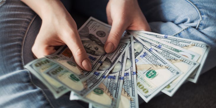 A woman fanning out a handful of cash.