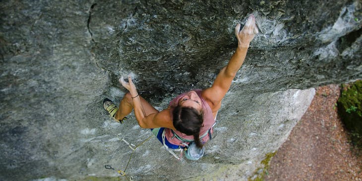 Uma mulher escalando uma montanha.