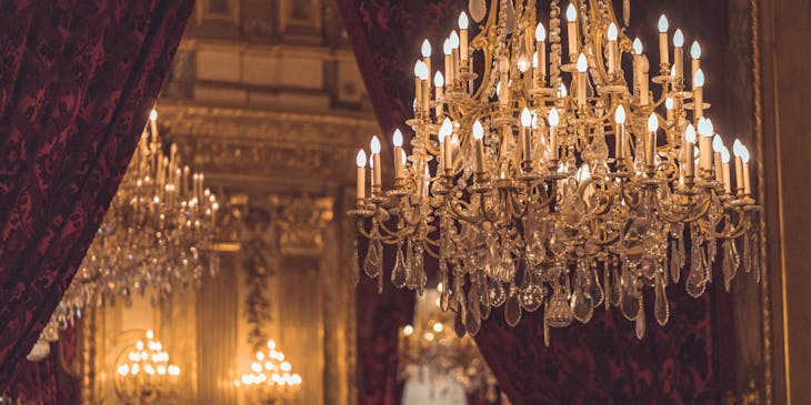 Un elegante candelabro frente a un par de cortinas de seda.