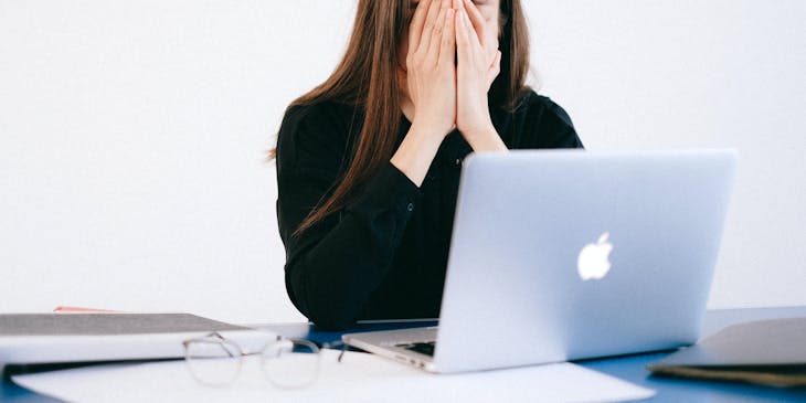 Woman holding her face after her employment was ended illegally.