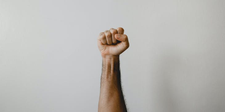 A man showing his endurance through a pumped up fist.