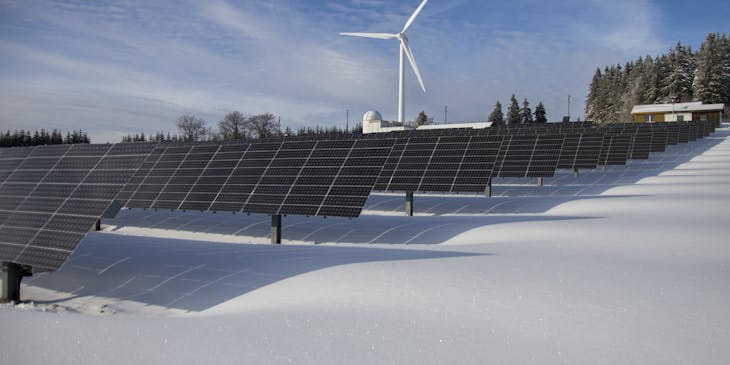 Solar panels across a snowy field at an energy business.