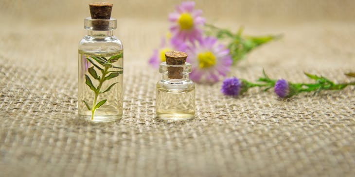 Aceites esenciales en botes con hierbas y flores.