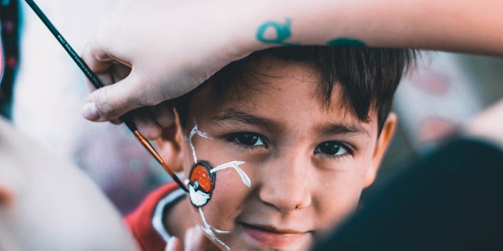 Little boy getting face painted.