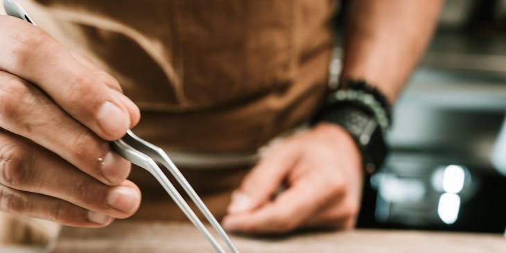 Un chef ajoutant les plus petits détails à un repas dans un restaurant chic.