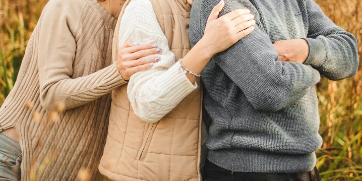 Un padre abrazado por sus dos hijas en un negocio de padre e hija.