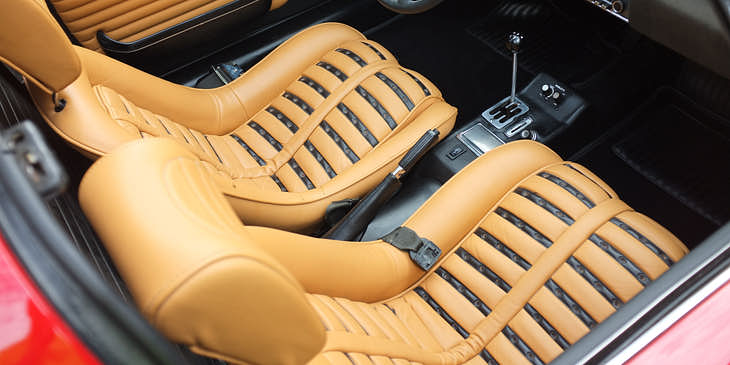 Interior de un auto deportivo con tapicería beige.