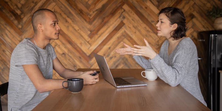 Une rédactrice freelance discute d'un dossier avec un client.