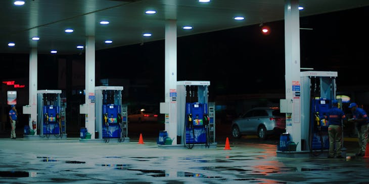 Gasolinera en colores blanco y azul con clientes.