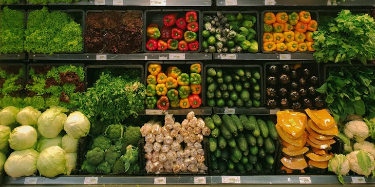 Legumes e vegetais em uma prateleira de uma mercearia.