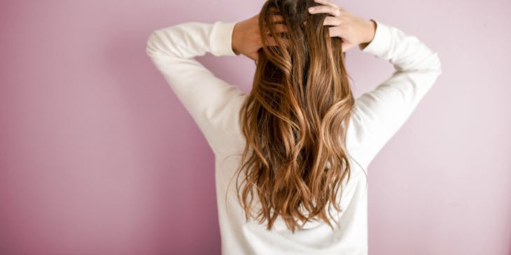 Mujer pasándose los dedos por el pelo en un negocio de productos para el cabello.