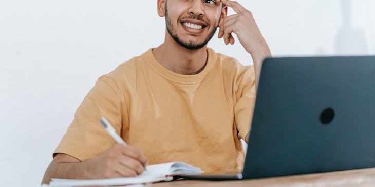 A man sitting at a desk thinking about a brand name idea.