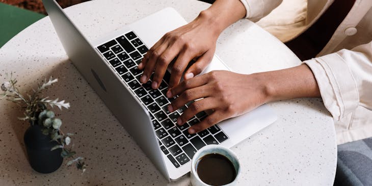 Manos en un teclado realizando una búsqueda de marcas en línea.