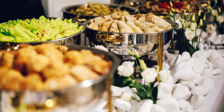 Comida servida en platos de plata en un negocio de catering.