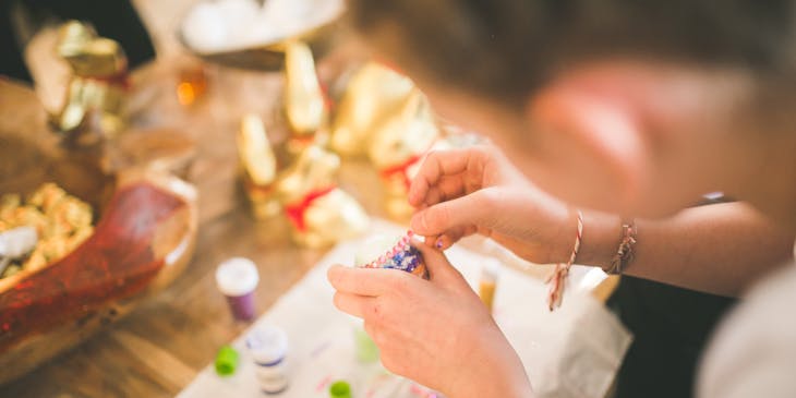 woman's hands working on beaded decoration