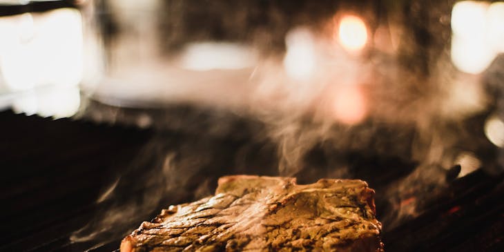 Carne asada al fuego en un asador.