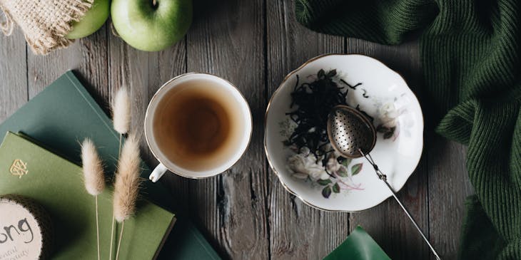 Una taza de té blanca sobre una mesa de madera café en una tienda de té.