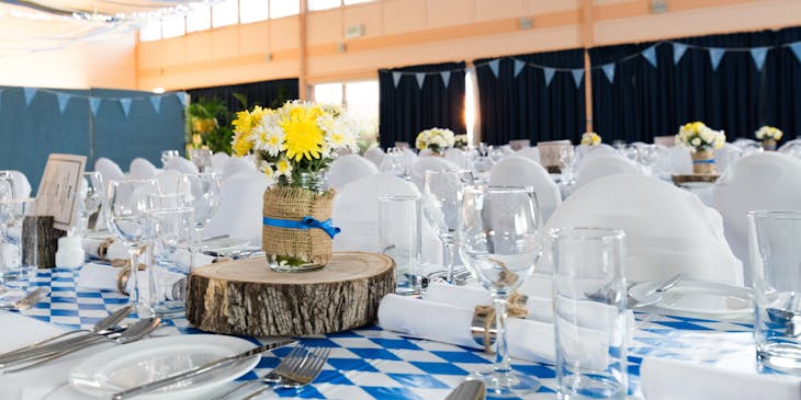 Un set de platos y vasos de vidrio en un negocio de eventos para un evento.