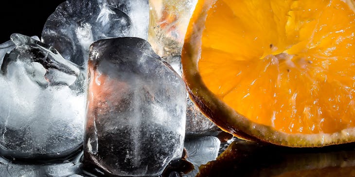 Cubos de gelo e uma fatia de laranja.